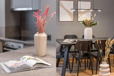 a kitchen counter with a table with a book and a vase with flowers at The Exarchia Hideout by UPSTREET in Athens