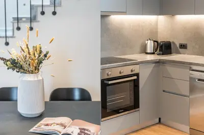 a kitchen with a table with a book and a vase of flowers at The Exarchia Hideout by UPSTREET in Athens