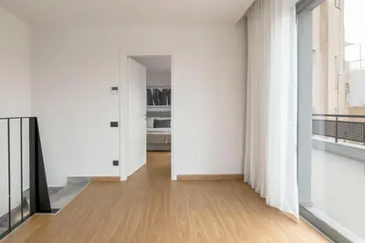 an empty room with white walls and wood floors at The Exarchia Hideout by UPSTREET in Athens
