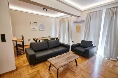 a living room with a couch and a table at Brand new Athens Museum Apt in Athens
