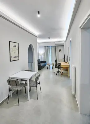 a living room with a table and chairs at Brand new Athens Museum Apt in Athens