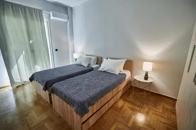 a bedroom with two beds and a window at Brand new Athens Museum Apt in Athens