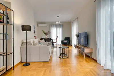 a living room with a white couch and a table at Seaside bliss in Alimos ideal for families ! in Athens