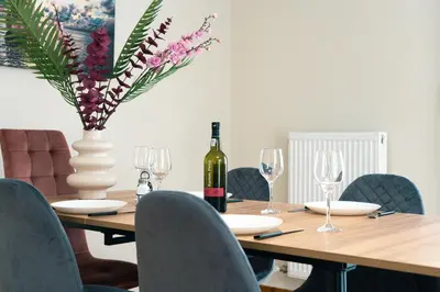a table with a bottle of wine and a vase with flowers at Seaside bliss in Alimos ideal for families ! in Athens