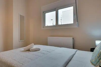 a bedroom with a white bed with a window at Seaside bliss in Alimos ideal for families ! in Athens