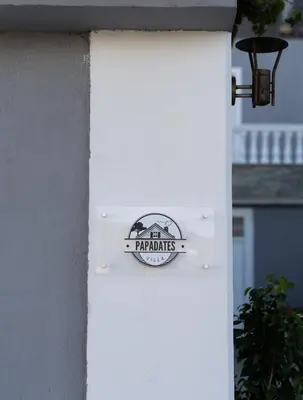 a sign on the side of a white house at Villa PAPADATES ARTEMIS in Barbaliáki