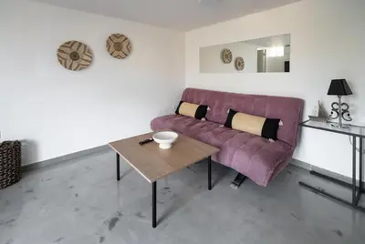 a living room with a purple couch and a table at Villa PAPADATES ARTEMIS in Barbaliáki