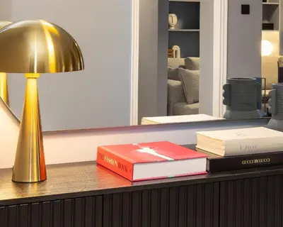 a stack of books sitting on a table with a lamp at Contempo Athens in Athens