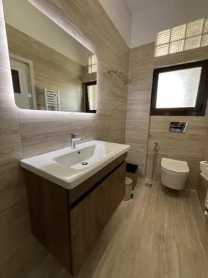 a bathroom with a sink and a toilet and a mirror at J&N Living in Spáta