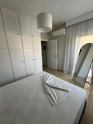 a bedroom with a white bed with a mirror at J&N Living in Spáta