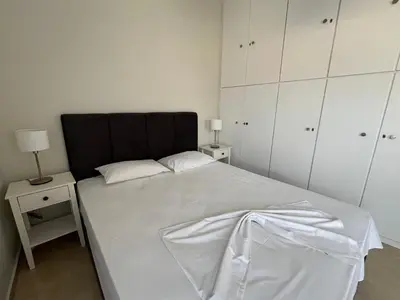 a bedroom with a bed with a black headboard and white cabinets at J&N Living in Spáta