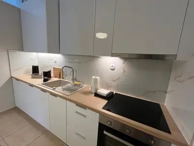 a kitchen with white cabinets and a sink at J&N Living in Spáta
