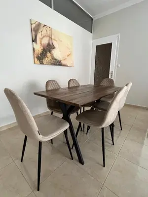 a dining room table with chairs and a painting at J&N Living in Spáta