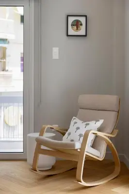 a rocking chair in a room with a window at Spacious Athenian escape, Koukaki in Athens