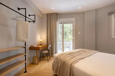 a bedroom with a bed and a desk and a window at Spacious Athenian escape, Koukaki in Athens