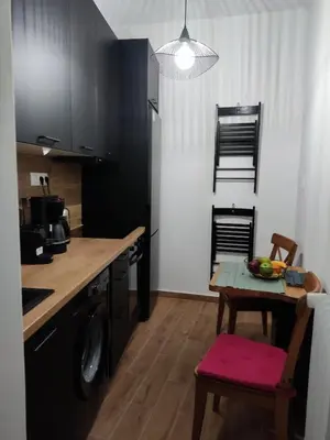 a kitchen with a table and a small table with a bowl of fruit at Renovated appartment, near Metro in Athens
