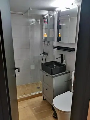 a bathroom with a sink and a toilet and a shower at Renovated appartment, near Metro in Athens