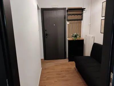 a living room with a black door and a couch at Renovated appartment, near Metro in Athens