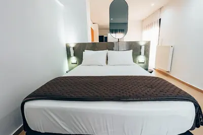a bedroom with a large white bed with two pillows at Luxury Superior Suite in Glyfada in Athens
