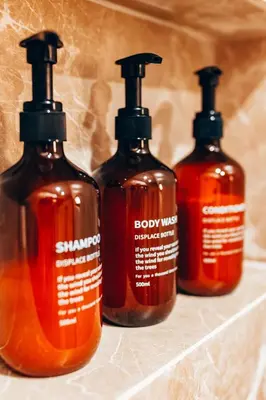 a group of four soap bottles sitting on a shelf at Luxury Superior Suite in Glyfada in Athens