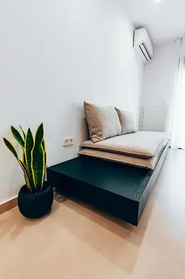 a bed in a room with a potted plant at Luxury Superior Suite in Glyfada in Athens