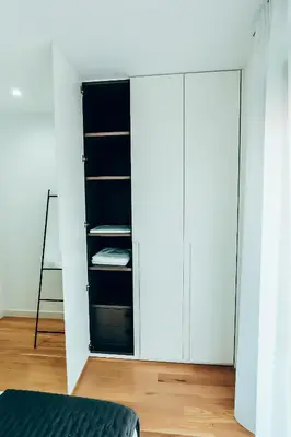 a bedroom with white cabinets and a bed at Dreamy Glyfada Apartment in Athens