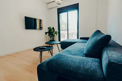 a living room with a blue couch and a tv at Dreamy Glyfada Apartment in Athens