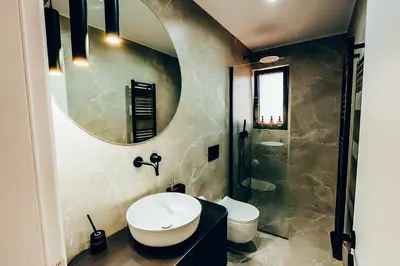 a bathroom with a sink and a toilet and a mirror at Dreamy Glyfada Apartment in Athens
