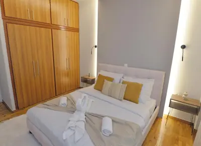 a bedroom with a large white bed with towels on it at Seren Studio near Victoria Metro-Earthy Tones & Comfort in Mesochórion