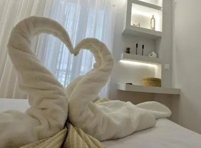 a towel animal shaped like a heart sitting on a bed at Seren Studio near Victoria Metro-Earthy Tones & Comfort in Mesochórion