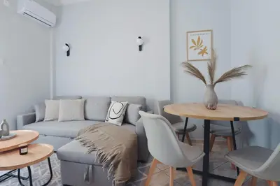 a living room with a couch and a table at Seren Studio near Victoria Metro-Earthy Tones & Comfort in Mesochórion