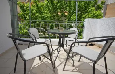 a table and four chairs on a balcony at Seren Studio near Victoria Metro-Earthy Tones & Comfort in Mesochórion