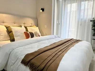 a bedroom with a large bed with white sheets and pillows at Larisis Cozy Corner in Athens