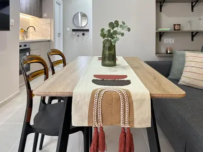 a dining room table with a vase of flowers on it at Larisis Cozy Corner in Athens