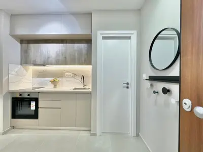 a white kitchen with a sink and a mirror at Larisis Cozy Corner in Athens