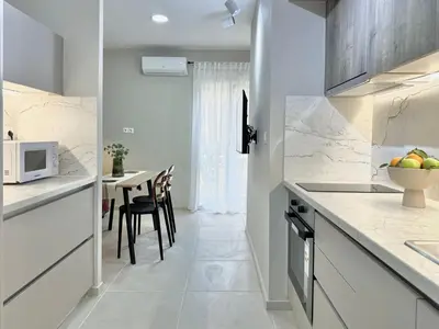 a kitchen with a counter and a table with chairs at Larisis Cozy Corner in Athens