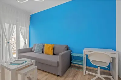 a living room with a couch and a blue wall at Kallari Serenity Apartment in Athens