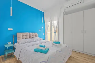 a blue room with a bed with towels on it at Kallari Serenity Apartment in Athens