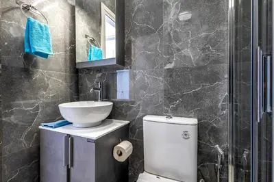 a bathroom with a white toilet and a sink at Kallari Serenity Apartment in Athens