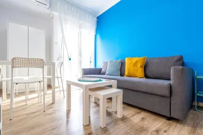a living room with a couch and a table and chairs at Kallari Serenity Apartment in Athens
