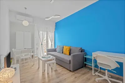 a living room with a couch and a blue wall at Kallari Serenity Apartment in Athens