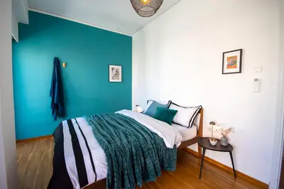 a bedroom with a bed with a blue wall at Avenue of Gods - Irakli's Retreat in Athens