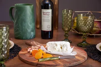 a wooden table with a plate of cheese and a bottle of wine at Avenue of Gods - Irakli's Retreat in Athens