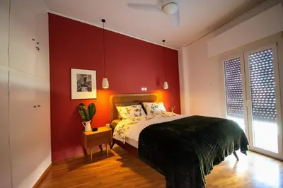 a bedroom with red walls and a bed in a room at Avenue of Gods - Irakli's Retreat in Athens