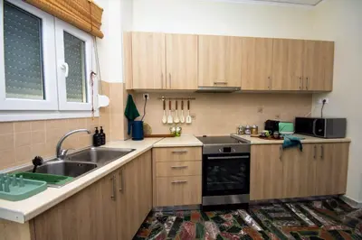 a kitchen with wooden cabinets and a sink at Avenue of Gods - Irakli's Retreat in Athens
