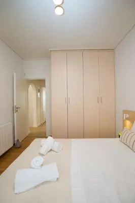 a bedroom with a large white bed with towels on it at K11 Apartment in Athens