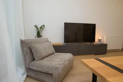 a living room with a chair and a flat screen tv at K11 Apartment in Athens