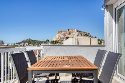 a table and chairs on a balcony with a view at Avra - Topfloor apartment in historical Athens in Athens