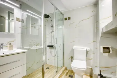 a bathroom with a toilet and a glass shower at Avra - Topfloor apartment in historical Athens in Athens