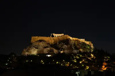 a castle on top of a mountain at night at Avra - Topfloor apartment in historical Athens in Athens